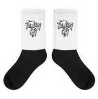 mockup image of 'Thinking Big Script' design on black and white crew socks